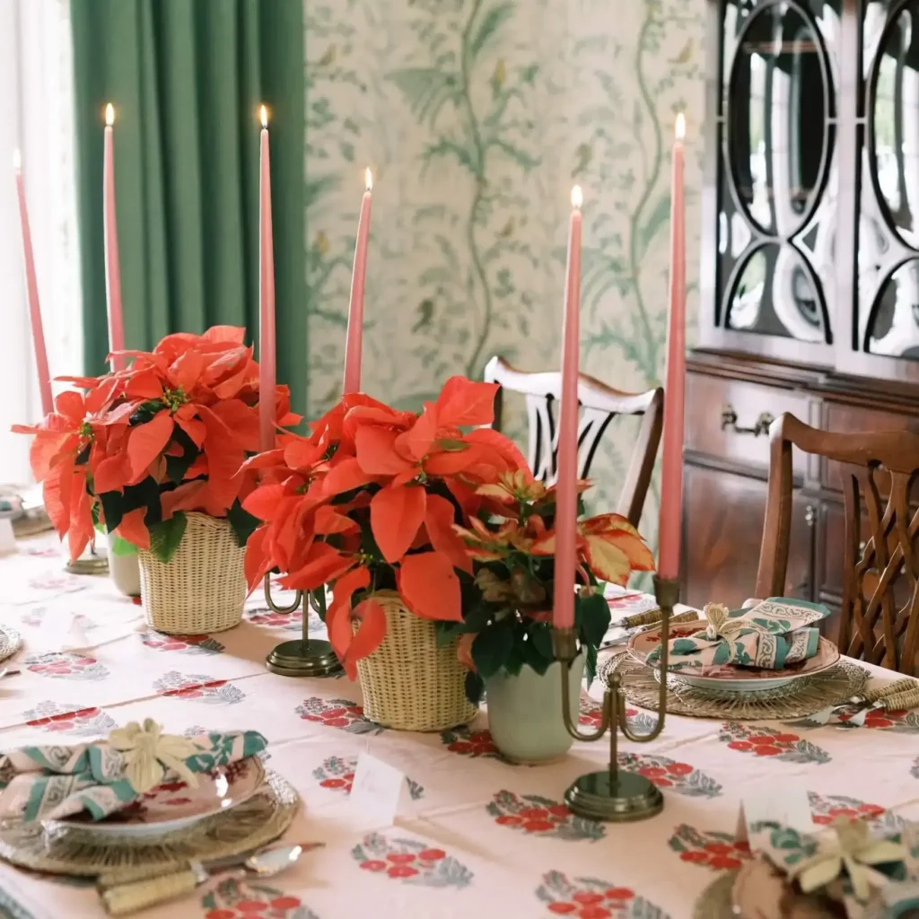 Holiday table setting with tablecloth, matching napkins, candles and poinsettias