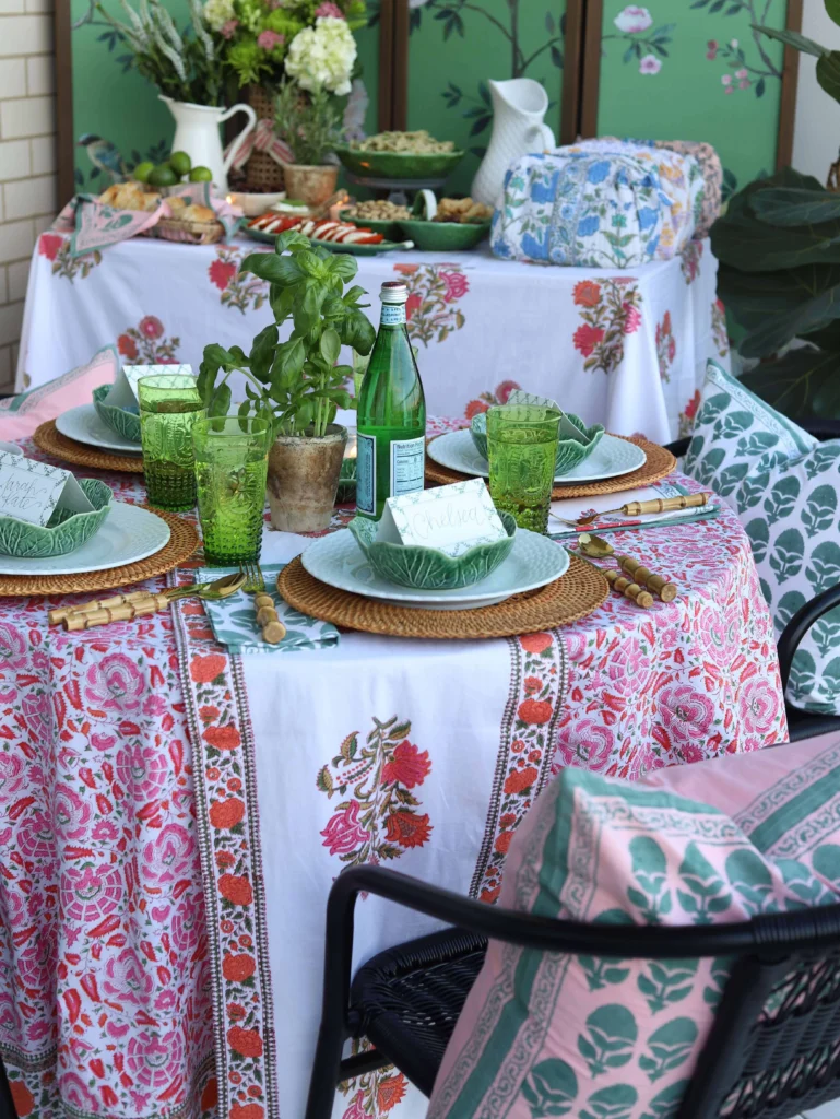 Holiday table setting with pink tablecloth, placemats, table runner and throw pillows