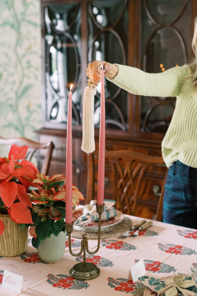 Lighting a holiday candle over a traditional holiday tablescape with a Indian block printed tablecloth.