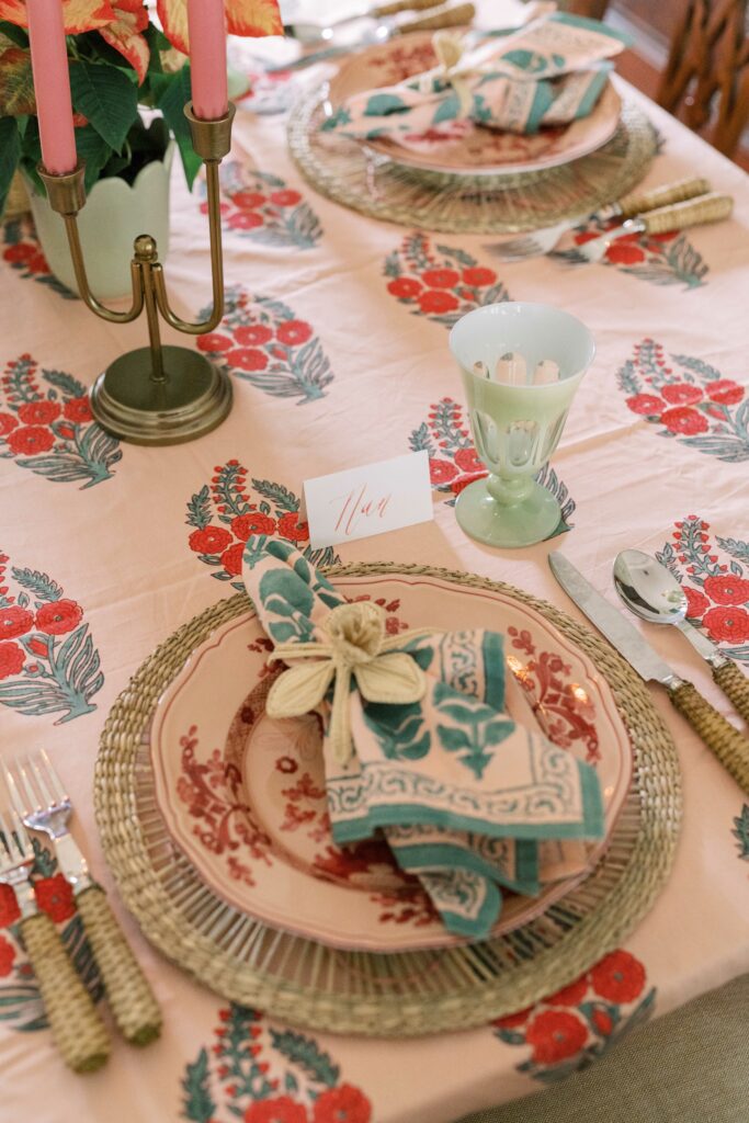 dining set from above, napkins on a plate, over traditional Indian block printed tablecloth featuring floral motifs