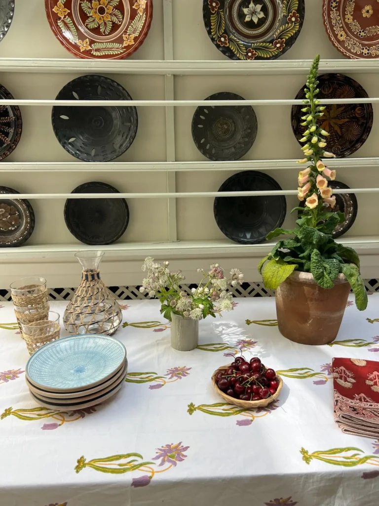 Summer end table setting with block print tablecloth and napkins and earthen plates in background